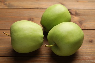 Photo of Fresh green apples on wooden table, closeup