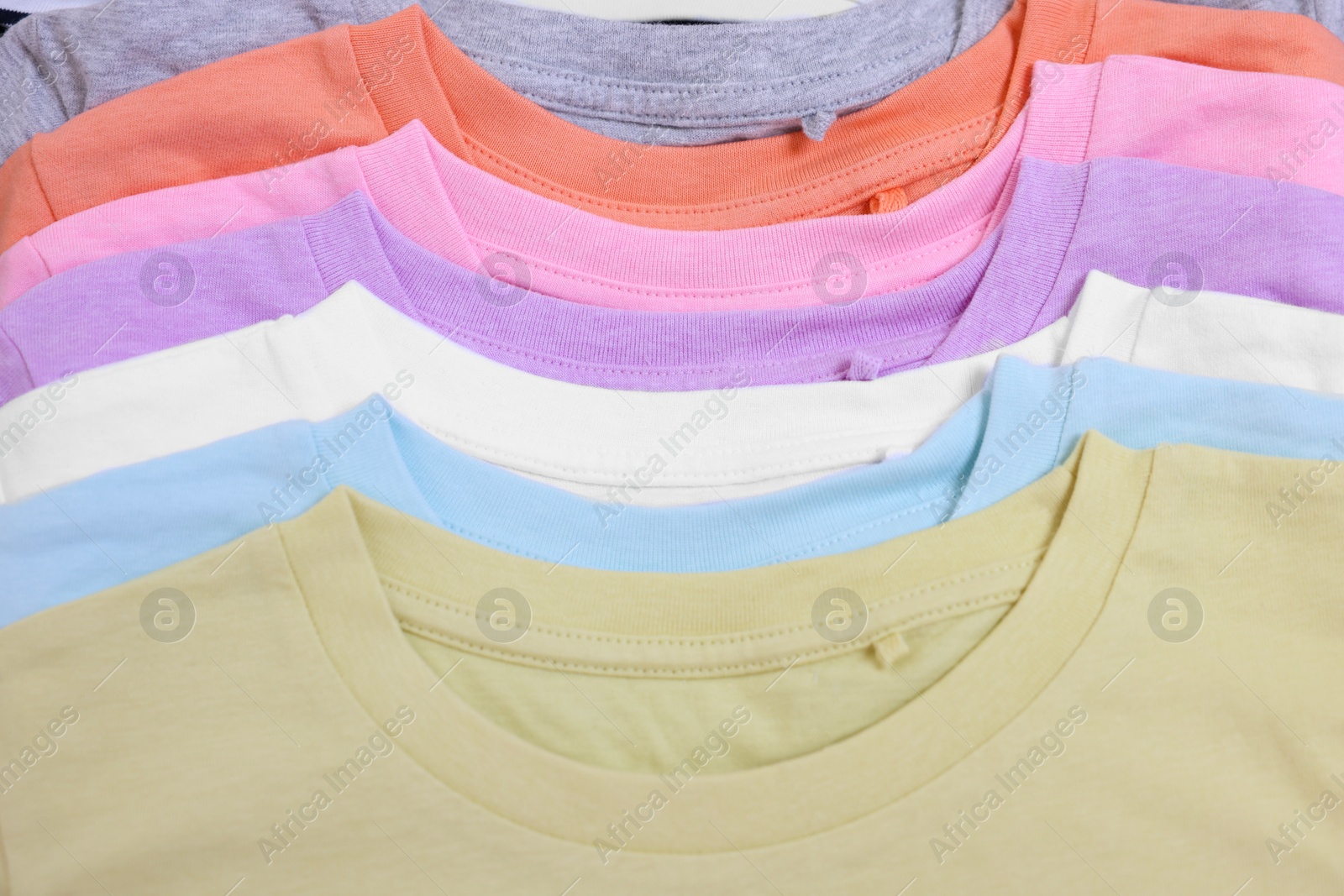 Photo of Many stacked clothes as background, top view