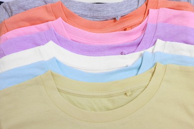 Photo of Many stacked clothes as background, top view