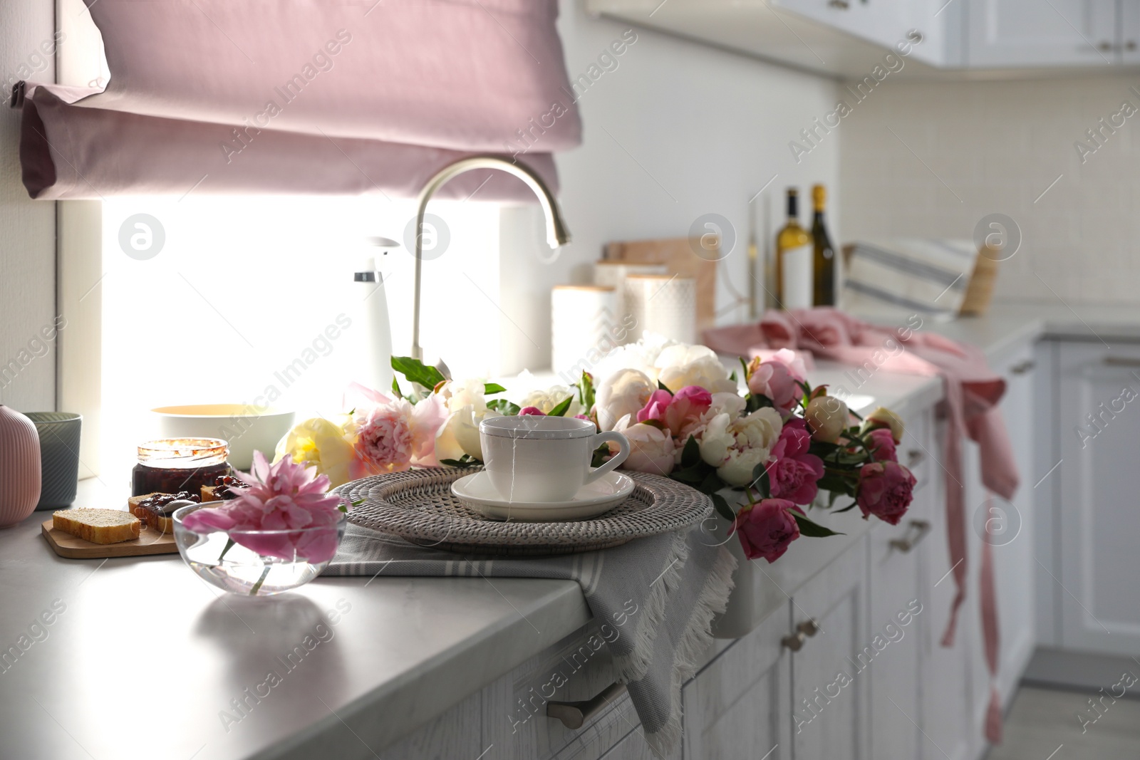 Photo of Beautiful peonies and breakfast on kitchen counter