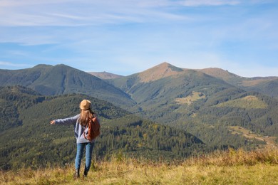 Photo of Young woman enjoying beautiful mountain landscape, back view