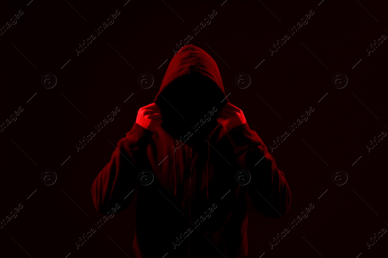 Photo of Silhouette of anonymous man on dark background, toned in red