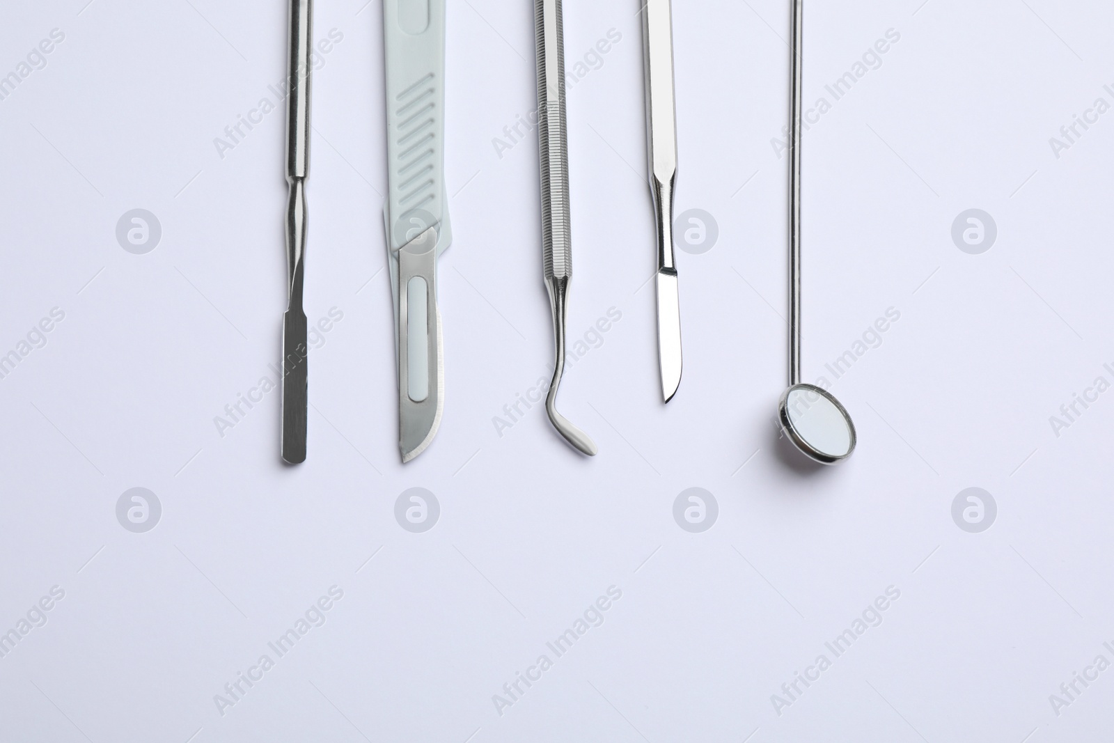 Photo of Set of different dentist's tools on light background, flat lay. Space for text