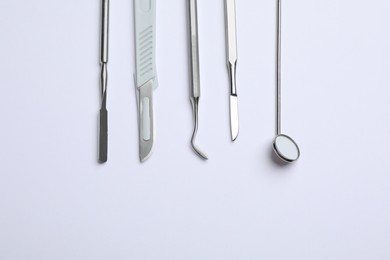 Set of different dentist's tools on light background, flat lay. Space for text