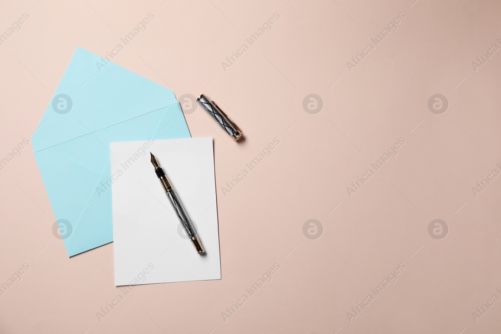 Photo of Blank sheet of paper, letter envelope and pen on beige background, top view. Space for text