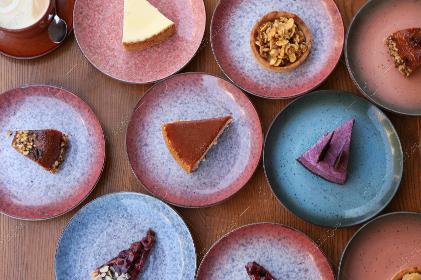 Photo of Plates with different cakes on wooden table, top view