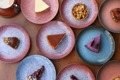 Photo of Plates with different cakes on wooden table, top view