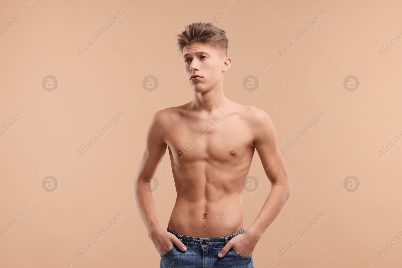 Photo of Shirtless man with slim body on beige background