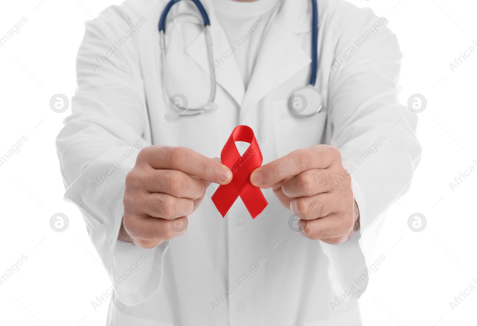 Photo of Doctor holding red awareness ribbon on white background, closeup. World AIDS disease day