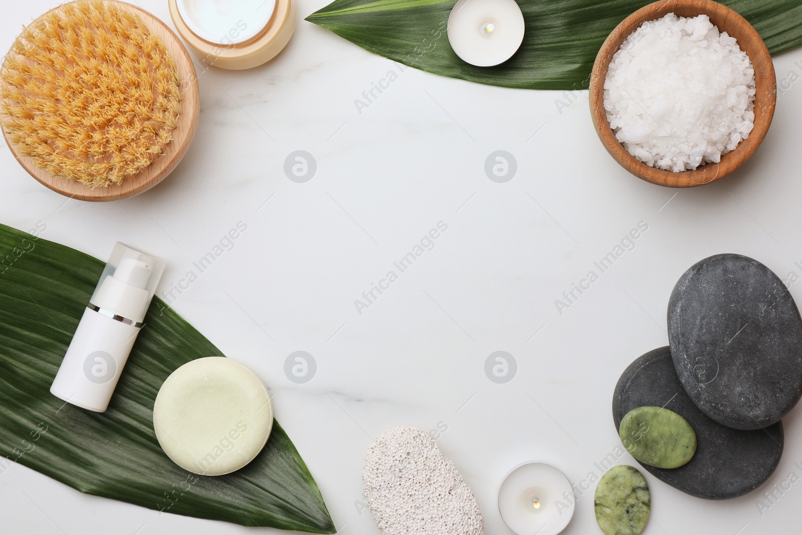 Photo of Frame made of different cosmetic products on white marble table, flat lay and space for text. Spa composition