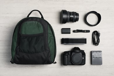 Photo of Professional photography equipment and backpack on wooden table, flat lay