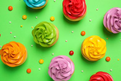 Colorful birthday cupcakes on green background, flat lay