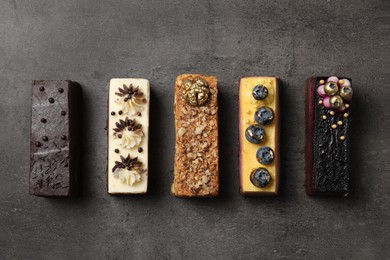 Different delicious cakes on grey table, flat lay