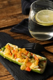 Photo of Baked stuffed zucchini served on wooden table, closeup