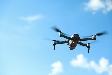 Photo of Modern drone with camera flying in sky on sunny day