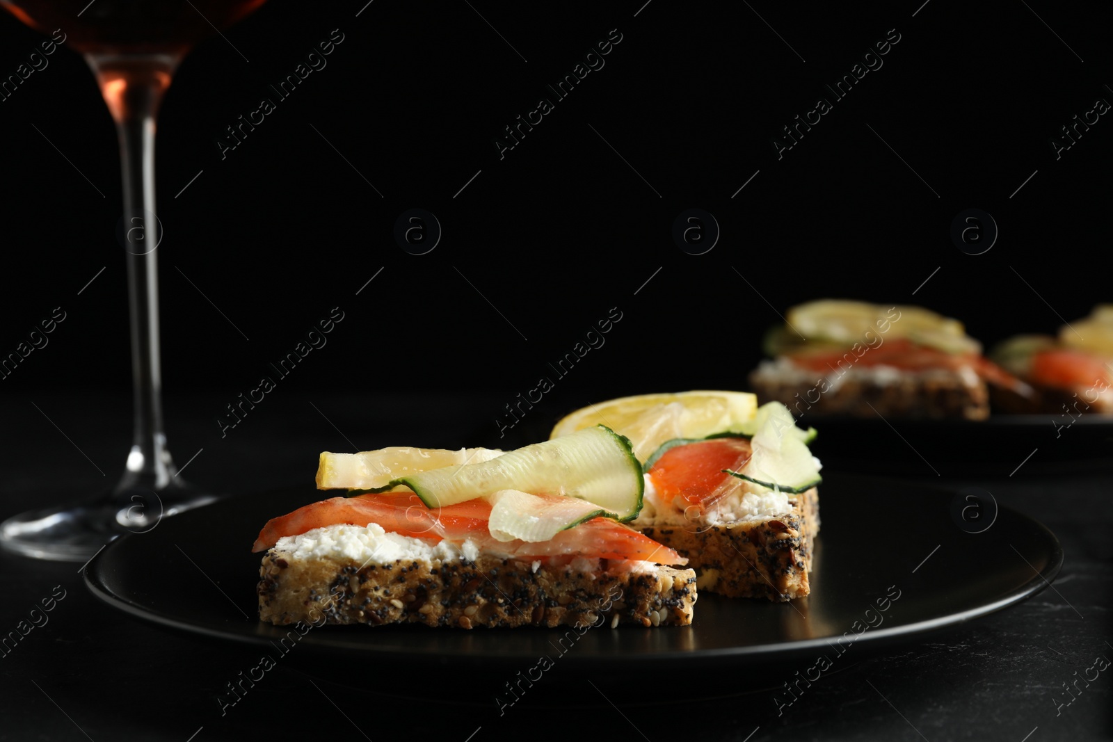 Photo of Delicious bruschettas with salmon served on black table