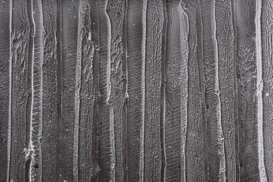 Photo of Wooden wall covered with hoarfrost on snowy day, closeup