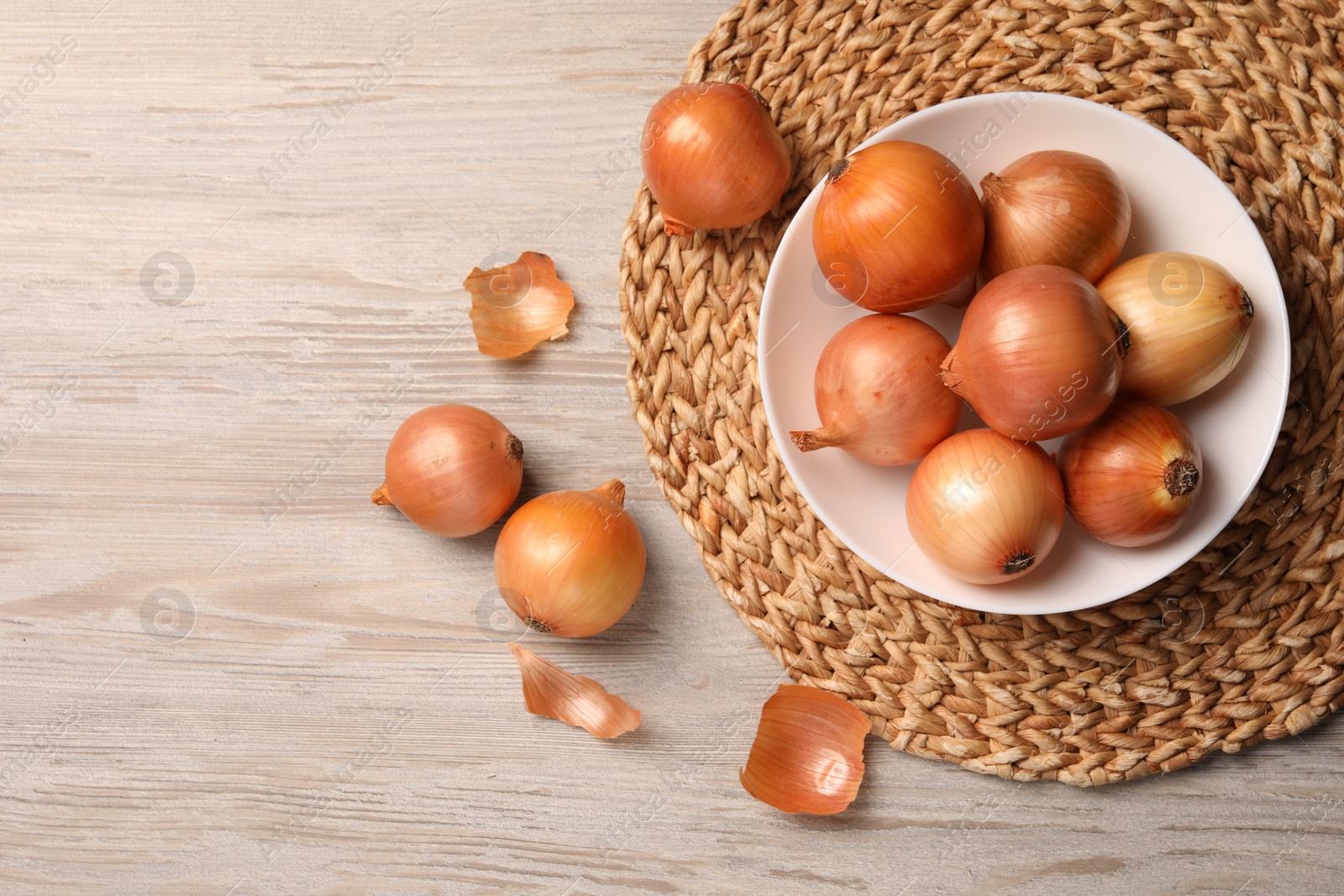 Photo of Many ripe onions on wooden table, flat lay. Space for text