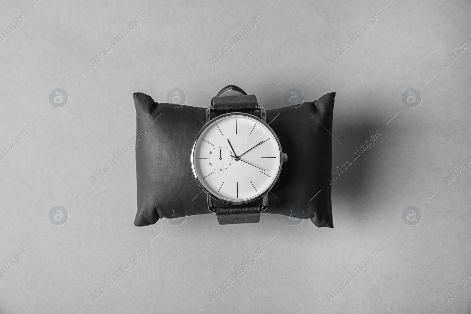 Photo of Small decorative pillow with stylish wrist watch on gray background, top view. Fashion accessory