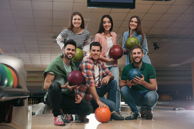 Photo of Group of friends with balls in bowling club