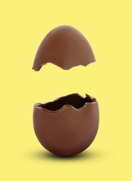 Image of Broken milk chocolate egg on yellow background