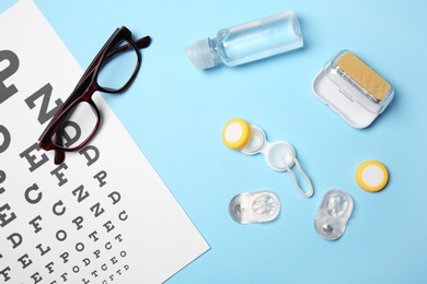 Photo of Flat lay composition with contact lenses, glasses and accessories on color background