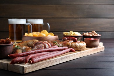 Set of different tasty snacks and beer on wooden table