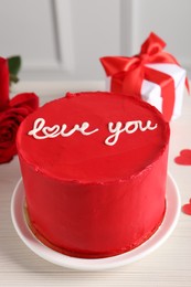 Photo of Bento cake with text Love You, roses and gift box on white wooden table, closeup. St. Valentine's day surprise