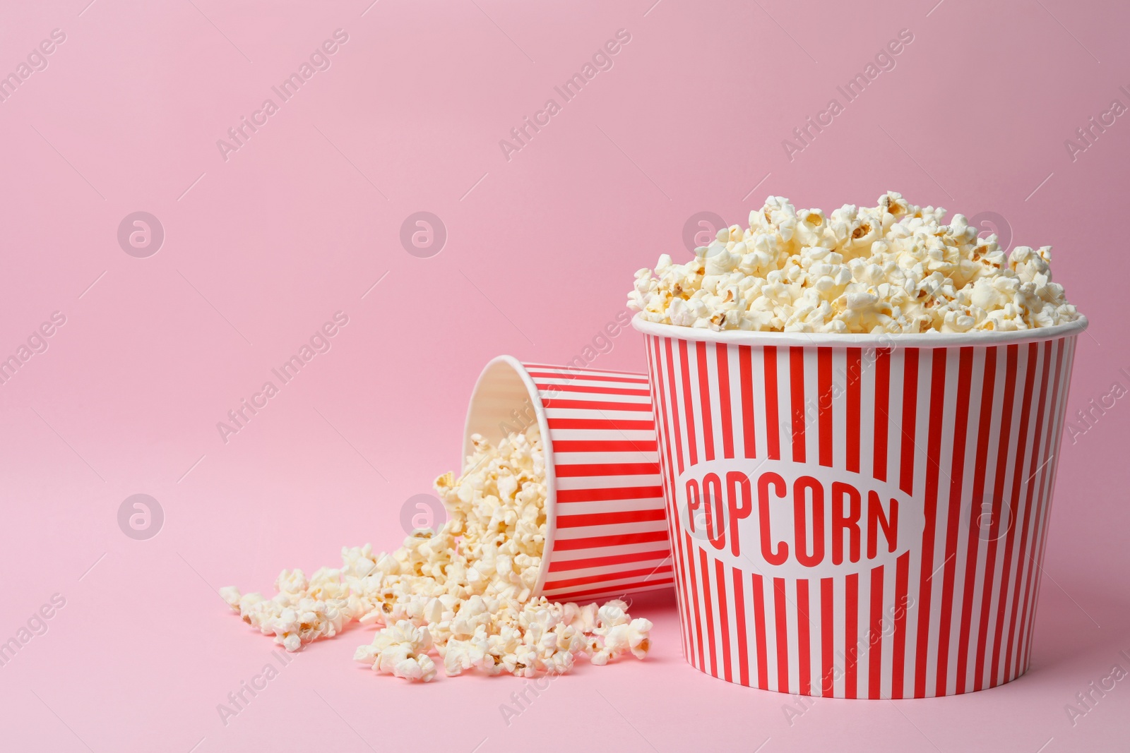 Photo of Fresh popcorn on pink background, space for text. Cinema snack