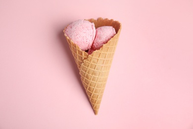 Photo of Delicious ice cream in wafer cone on pink background, top view
