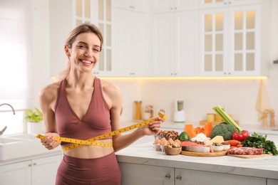 Photo of Woman with measuring tape and different products in kitchen. Keto diet