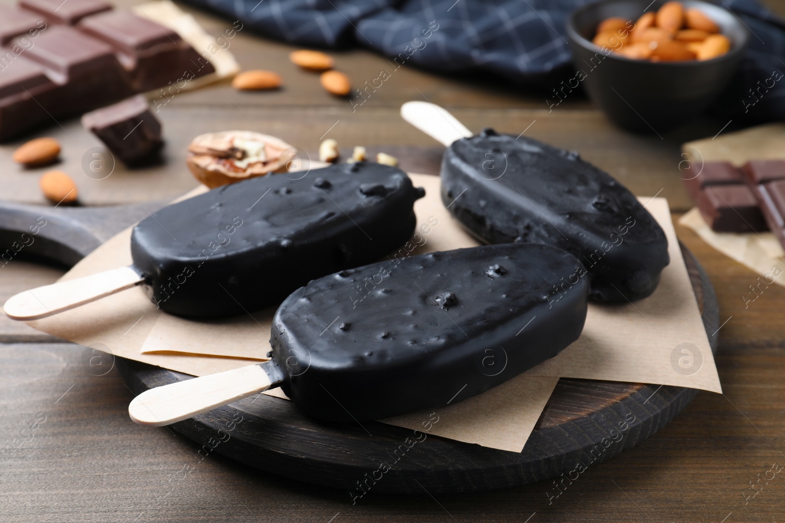 Photo of Delicious glazed ice cream bars on wooden table