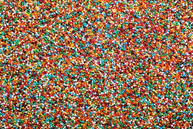 Bright colorful sprinkles as background, top view. Confectionery decor