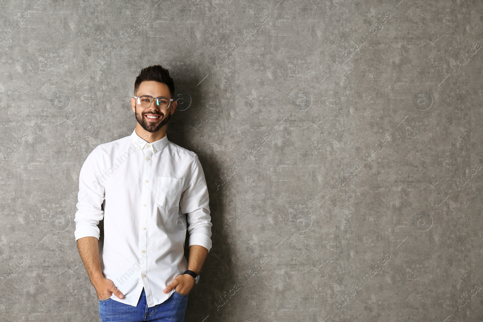 Photo of Portrait of handsome smiling man in glasses on grey background. Space for text