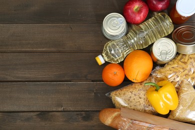 Photo of Different donation food on wooden table, flat lay. Space for text