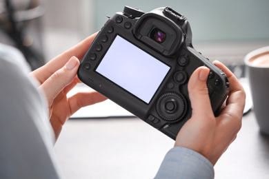 Journalist with camera at table in office, closeup