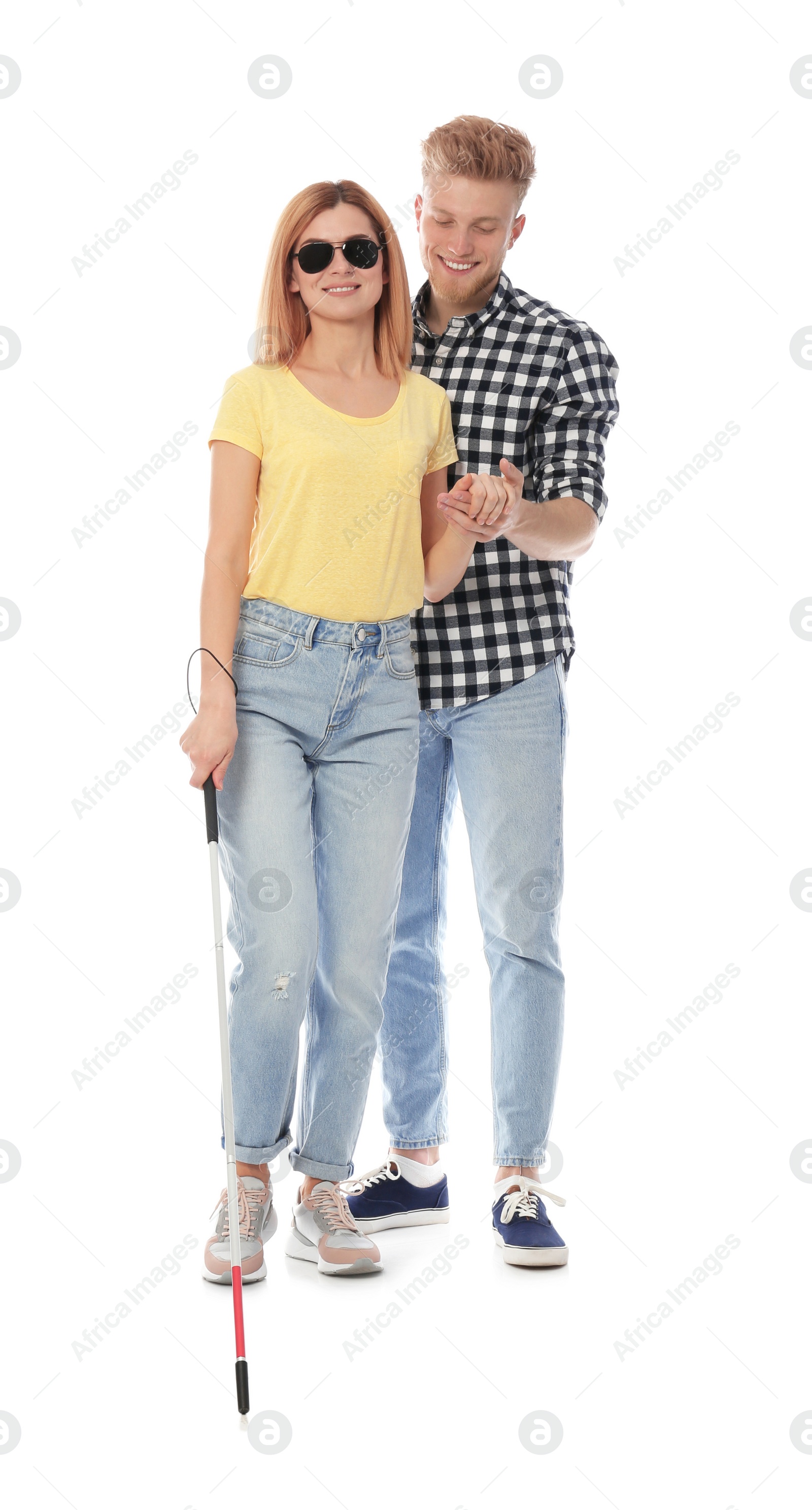 Photo of Young man helping blind person with long cane on white background