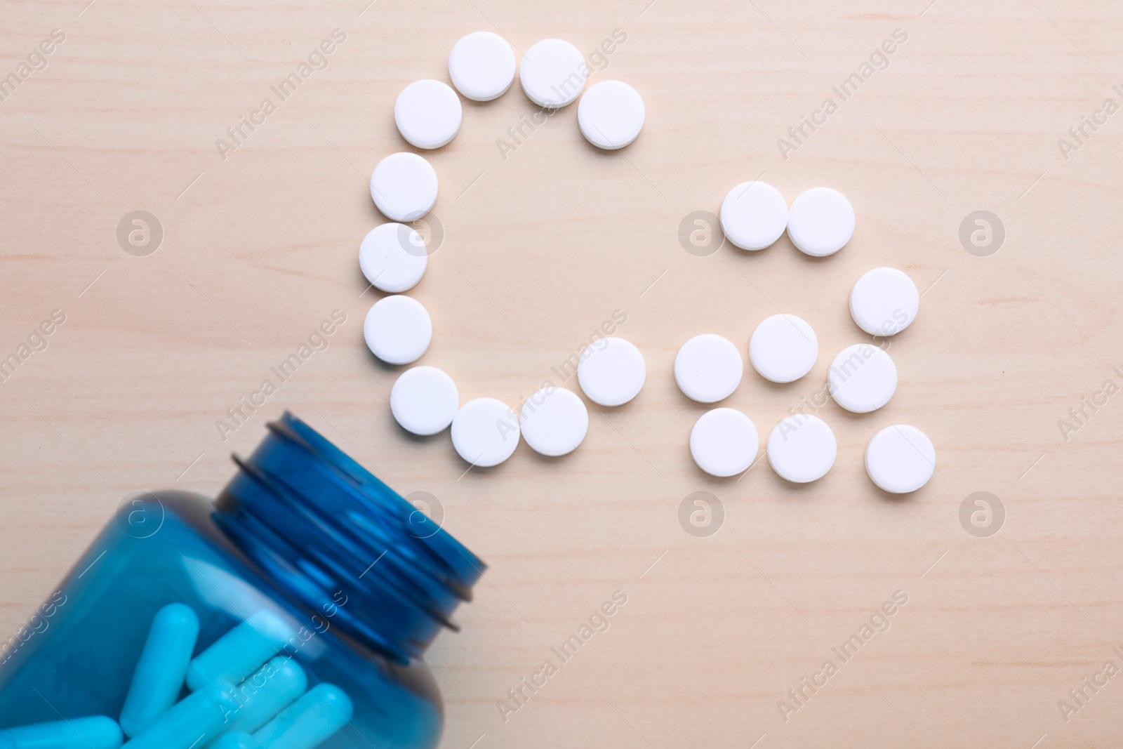 Photo of Symbol Ca (Calcium) made of pills and medical bottle on violet background, top view