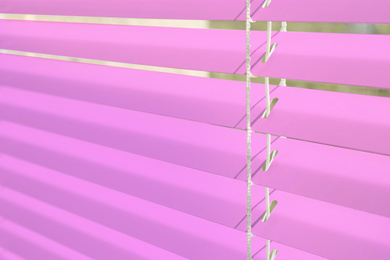 Image of Window with pink horizontal blinds, closeup view