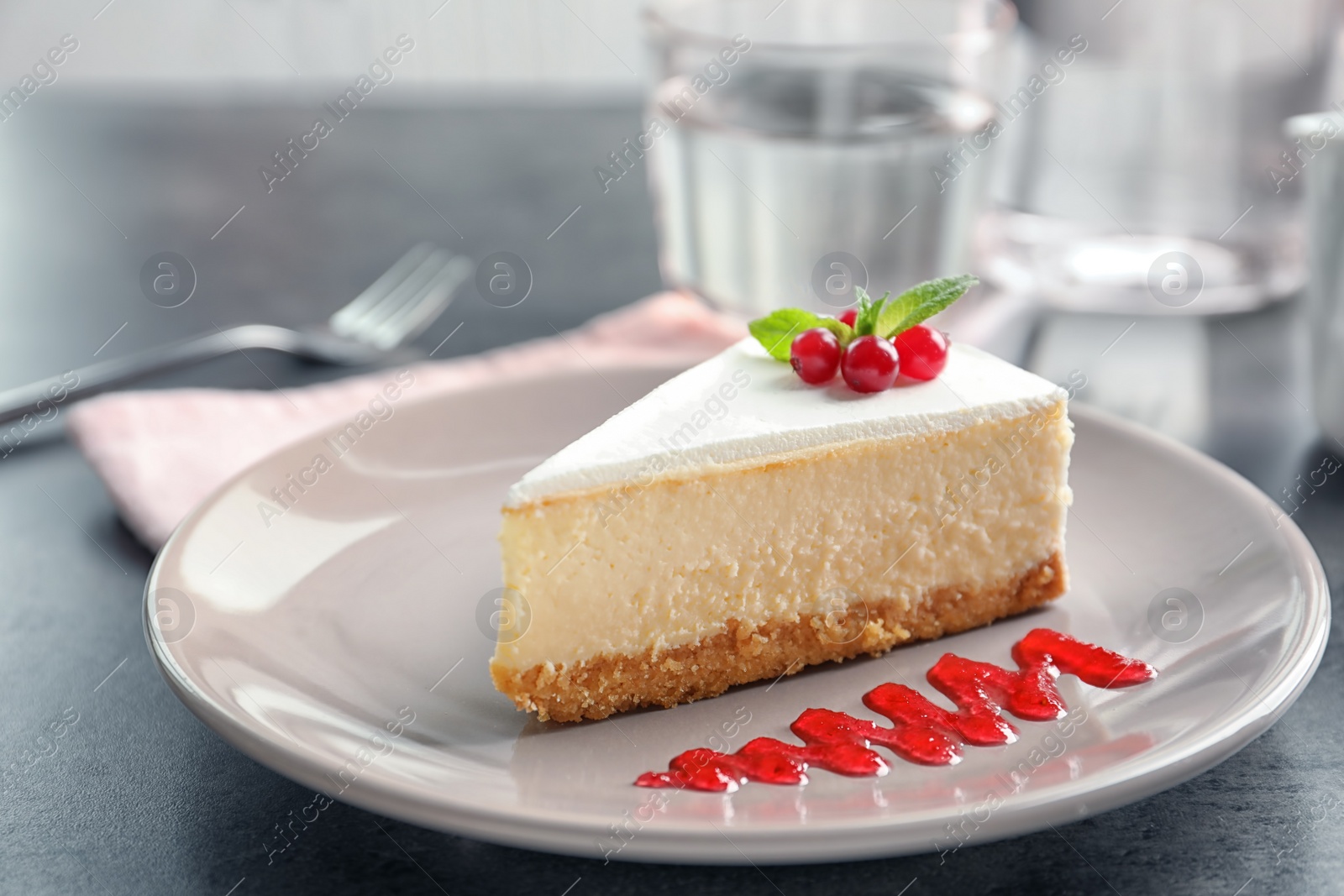 Photo of Delicious cheesecake served with sweet jam on plate