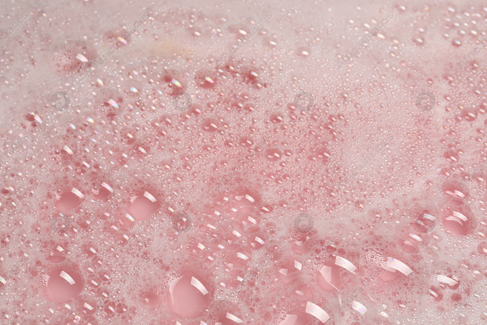 Photo of Colorful foam after dissolving bath bomb in water, closeup