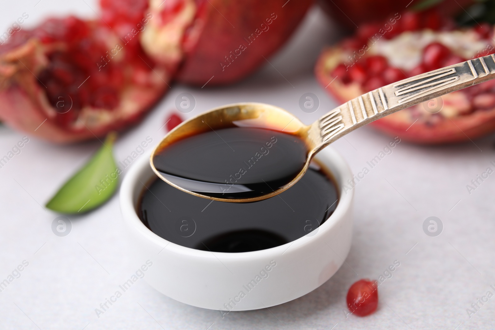 Photo of Tasty pomegranate sauce on light table, closeup