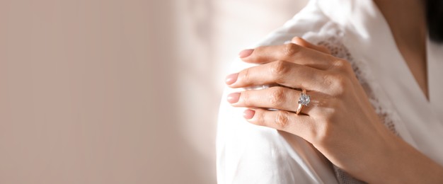 Image of Young woman wearing beautiful engagement ring, closeup view with space for text. Banner design