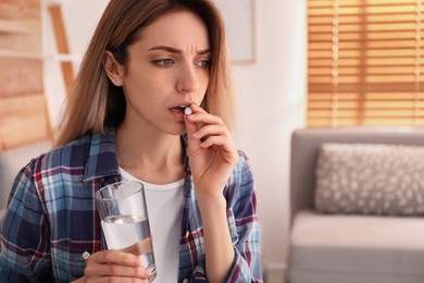 Photo of Upset young woman taking abortion pill at home