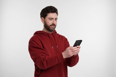 Photo of Handsome man with smartphone on white background