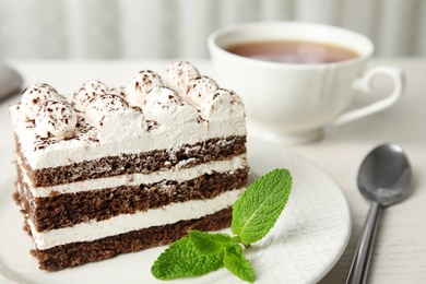 Photo of Tiramisu cake with cup on table, closeup. Space for text