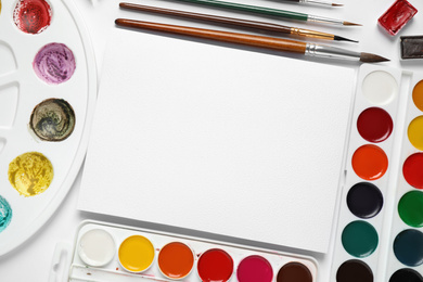 Photo of Watercolor paints, brushes and blank paper with space for design on white background, flat lay