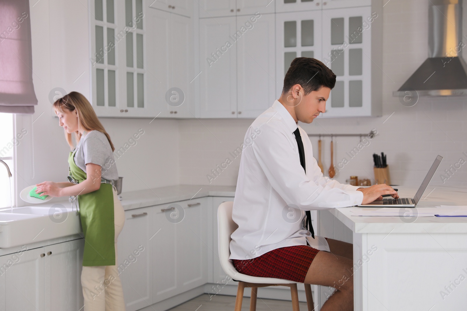 Photo of Man working on laptop in kitchen. Stay at home concept