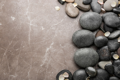 Stones and flower petals on brown marble background, flat lay. Zen lifestyle