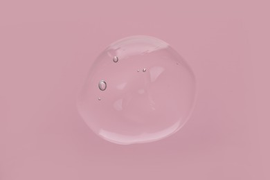 Photo of Sample of cleansing gel on pink background, top view. Cosmetic product